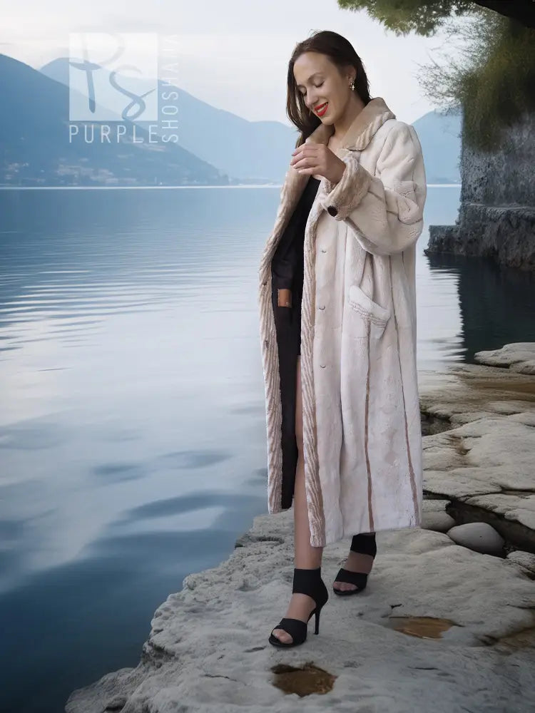 Cream beaver fur coat with buttonless open front and long sleeves.