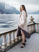 Side view of a cream sheared beaver fur coat with open front and mid-calf hem