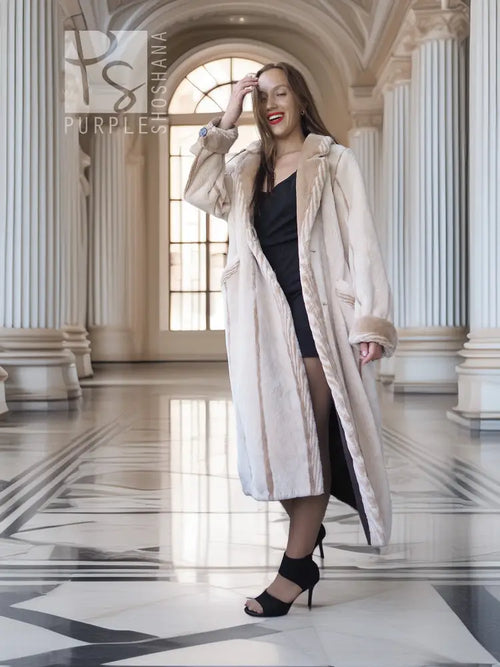 Cream fur coat with open front and plush shawl collar; long mid-calf length.