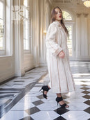 Cream beaver fur coat with notched collar, belted waist detail, and long sleeves