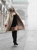Beige mink fur coat over black dress, featuring open front and long sleeves