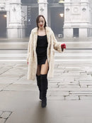 Beige mink fur coat with open front and long sleeves, worn with red gloves