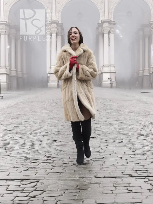 Beige mink fur coat in front view with open collar and red gloves