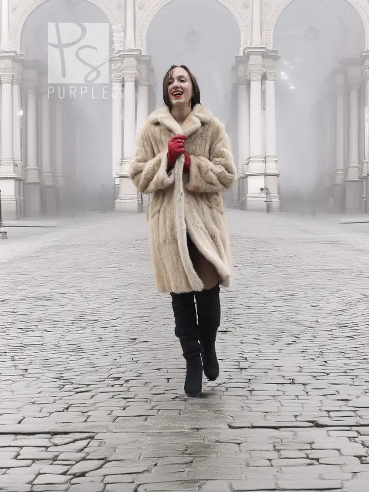 Beige mink fur coat in front view with open collar and red gloves