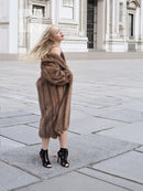 Brown mink fur coat in side profile, shawl-style collar and knee-length hem