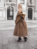 Brown mink fur coat with high collar, long sleeves, flared midi silhouette.