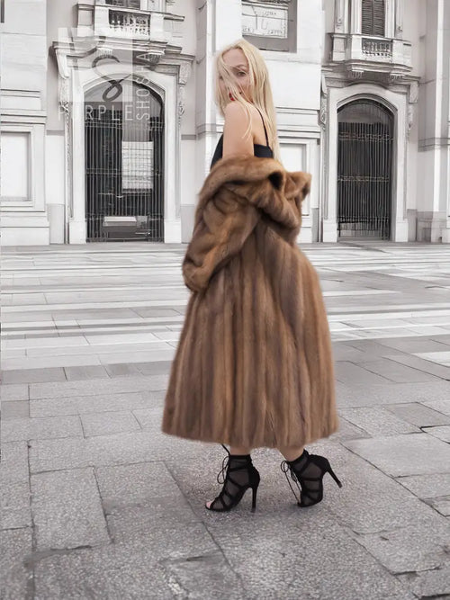 Brown mink fur coat with high collar, long sleeves, flared midi silhouette.