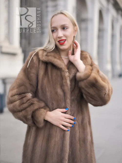 Brown mink fur coat with hood, close-up on shoulders and neckline.