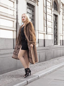 Brown mink fur coat with fur collar and open front, worn with black mini dress