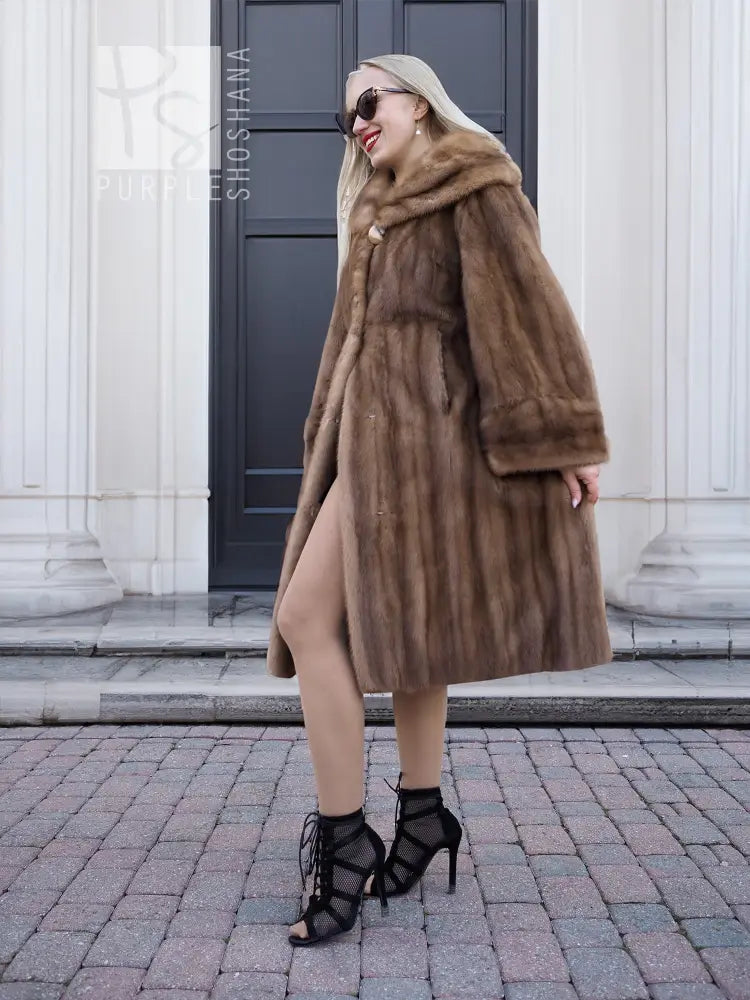Brown mink fur coat with hood, mid-calf length, side pockets, relaxed fit.