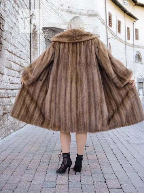 Brown mink fur coat back view, flared mid-calf hem, textured fur detail.