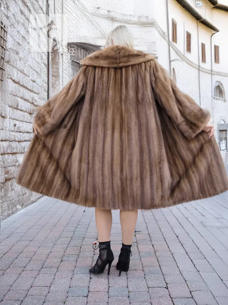 Brown mink fur coat back view, flared mid-calf hem, textured fur detail.