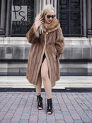 Vintage mink fur coat with hood, brown fur, hands near collar, standing