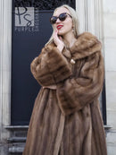 Brown mink fur coat close-up, hooded collar and buttoned front, long sleeves