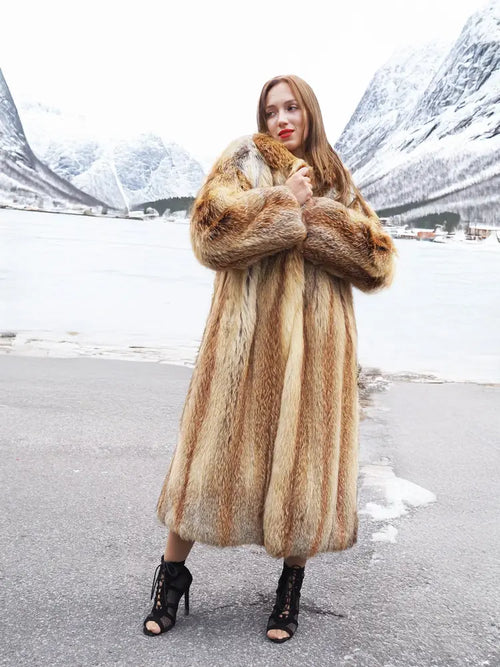 Long hooded fur coat in tan and brown with open front, belted look, thigh slit.