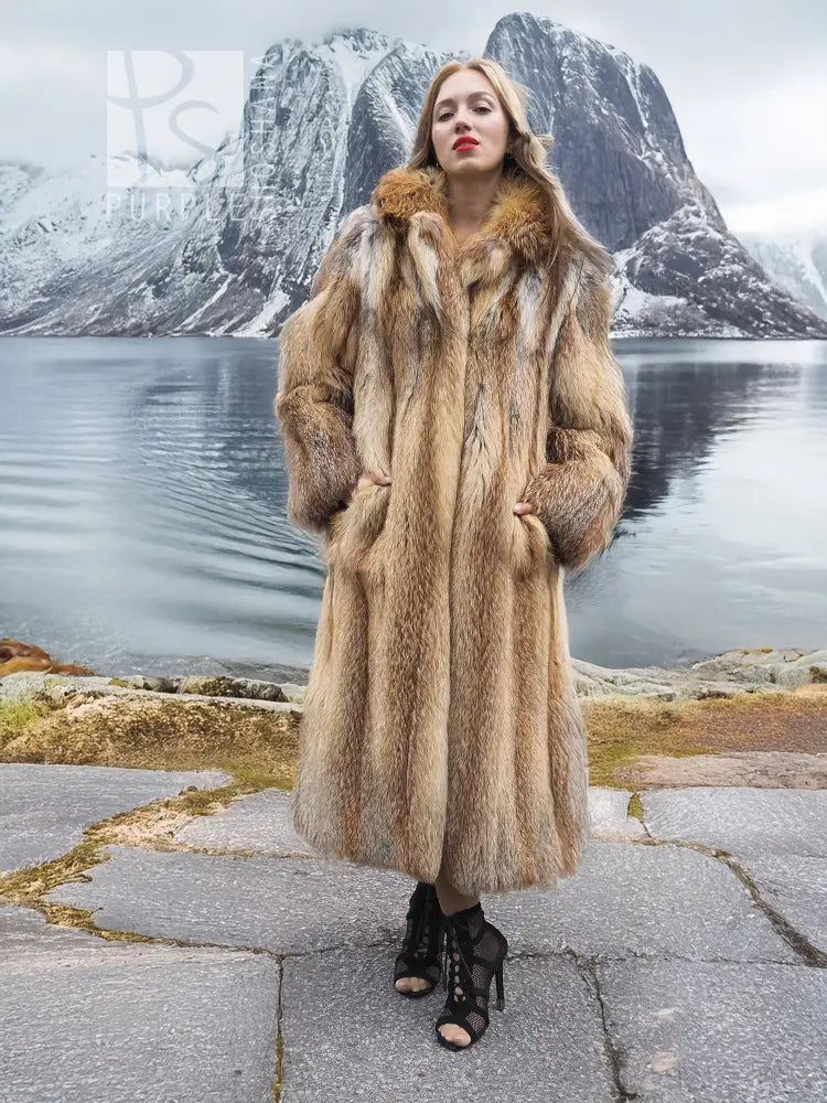 Long hooded fur coat in tan and brown with open front and full-length sleeves.