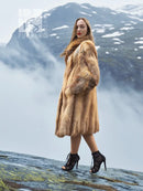 Tan fur coat with long sleeves and textured fur panels, side profile.