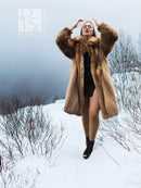 Tan fur coat with hood-like collar and open neckline over dark dress.