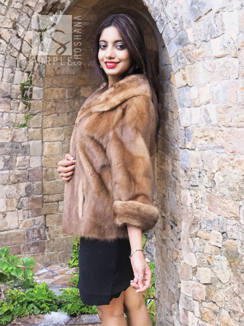 Beige mink fur opera jacket side profile with textured fur panels and cuffs.