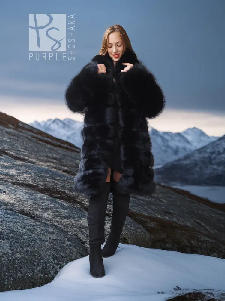 Black fox fur shawl-collar coat, full length with fitted waist and long pile.