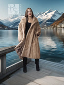 Beige full-length mink coat with fur collar and draped sleeves, black leggings