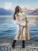 Tan faux fur coat with shawl collar and full length hem, styled with black knee-high boots